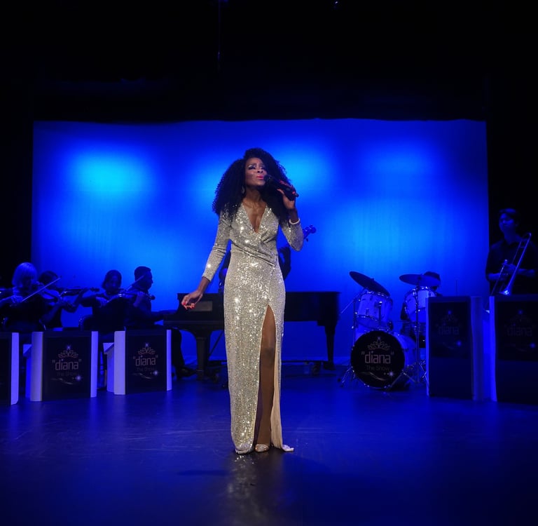 a woman in a gold dress standing in front of a stage