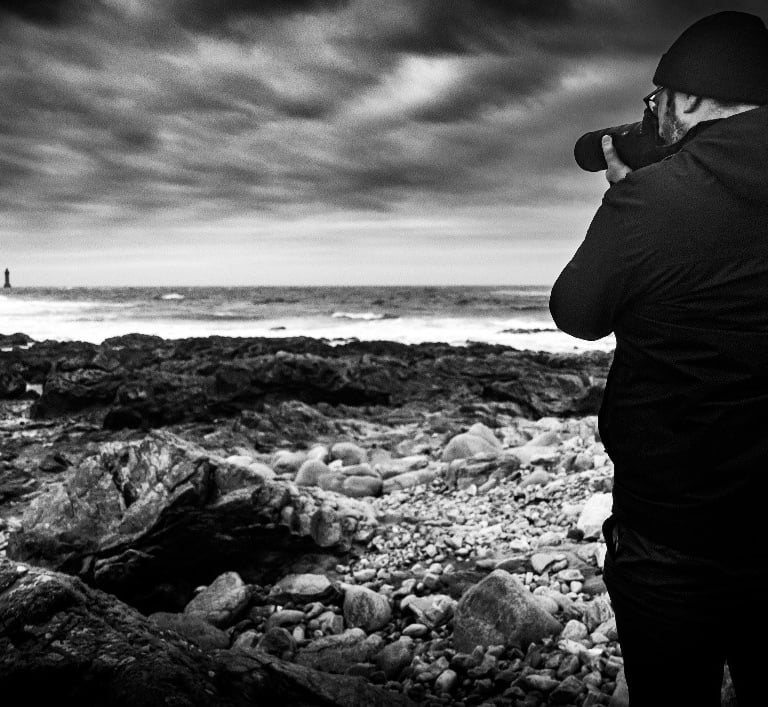 Photo noir et blanc de Anthony Leclerc qui prend une photo du phare de la jument
