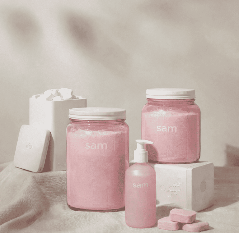 Envases rosa pastel de SAM Cosméticos en colección de belleza elegante y minimalista.