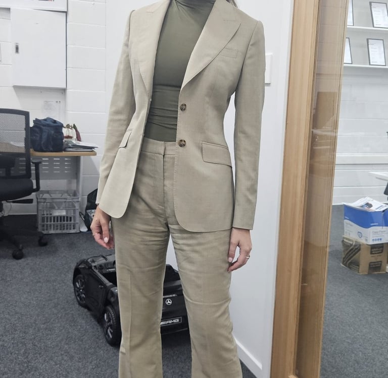 a woman in a suit and heels standing in a room