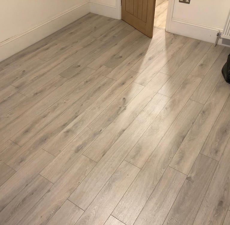Light wood laminate flooring installation in a room completed by Diamond Decor in Brighton