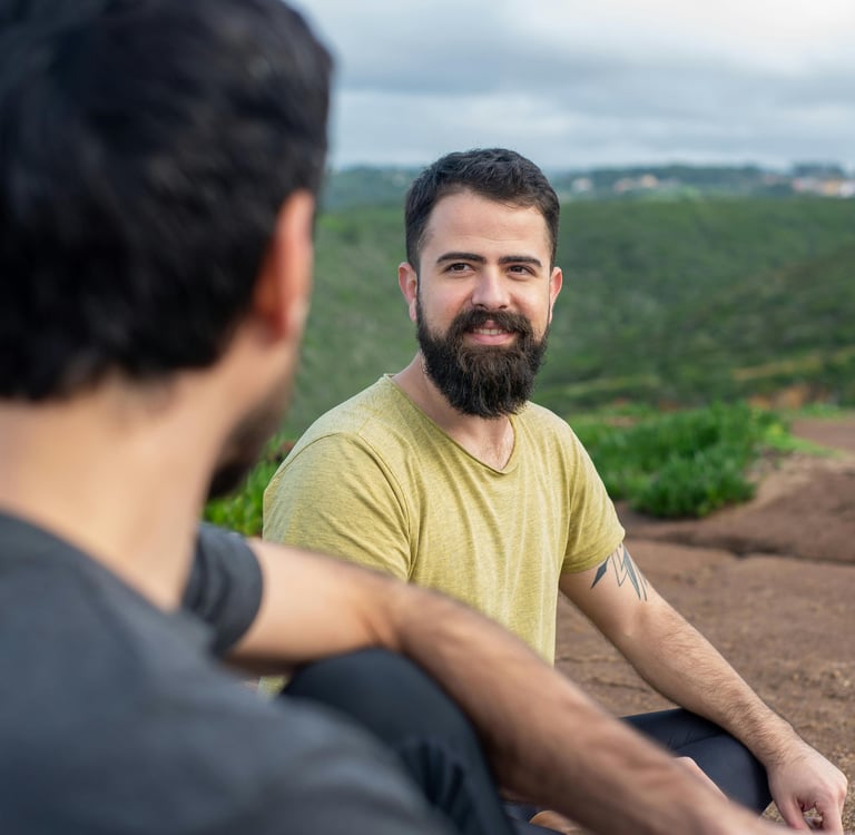 Two men having a conversation in the green countryside.