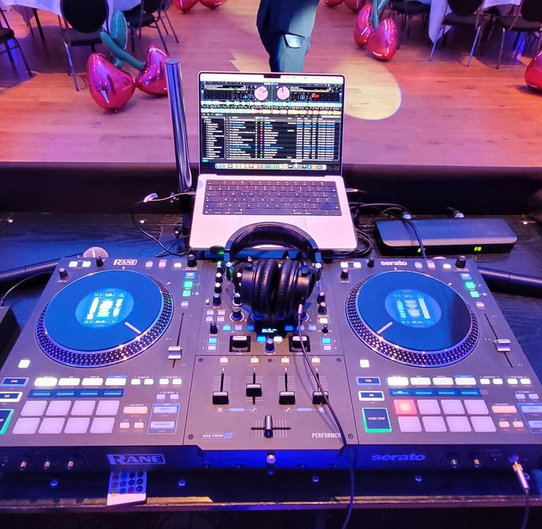 Professional Rane DJ controller setup with laptop and headphones at a party venue with cherry balloons.