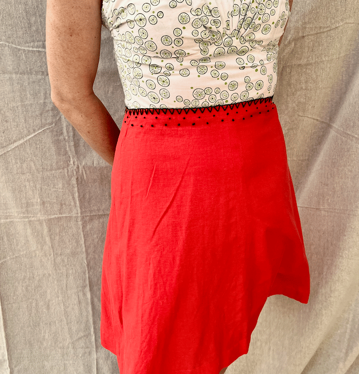 A strappy sundress with a green/white bodice and bright red skirt