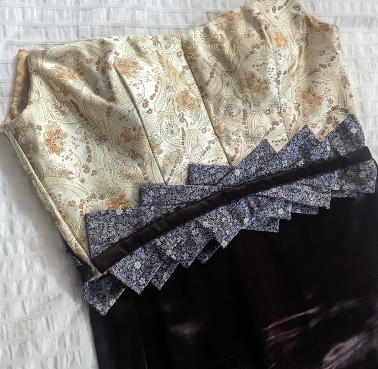 The front of the bodice of a gold brocade and brown satin evening gown