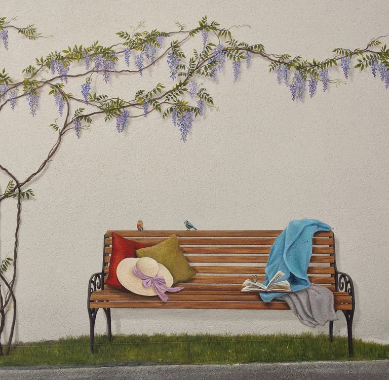 Fresque en trompe-l'oeil sur façade. Un banc posé sur l'herbe, des oiseaux, un livre et une glycine.