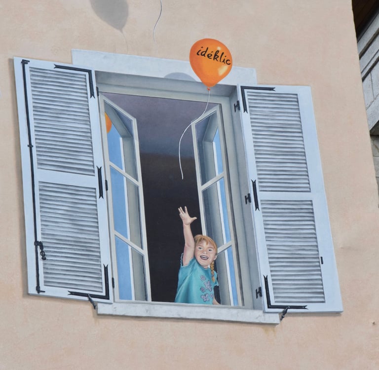 Détails d'une fenêtre en trompe-l'oeil peint sur une façade, un enfant avec ballons Ideklic, Jura 39
