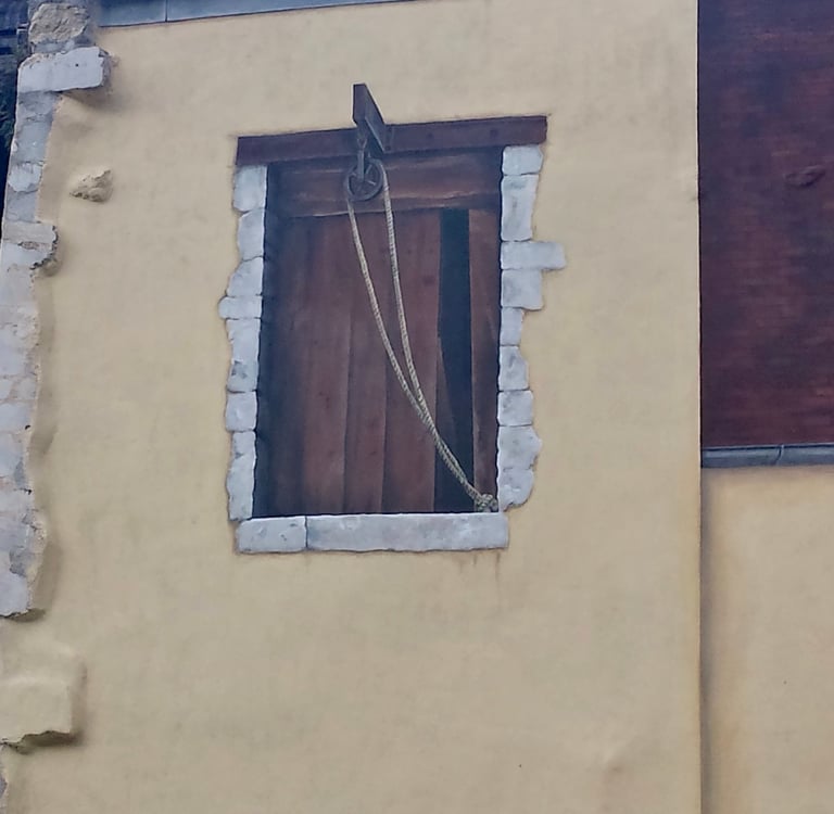 Fenêtre d'atelier peinte en trompe-l'oeil sur une façade à Moirans-en-Montagne dans le Jura, 39.