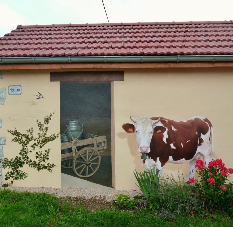 Fresque murale réalisée sur une façade, fausse porte, vache, lierre, pierres: tout est peint !...