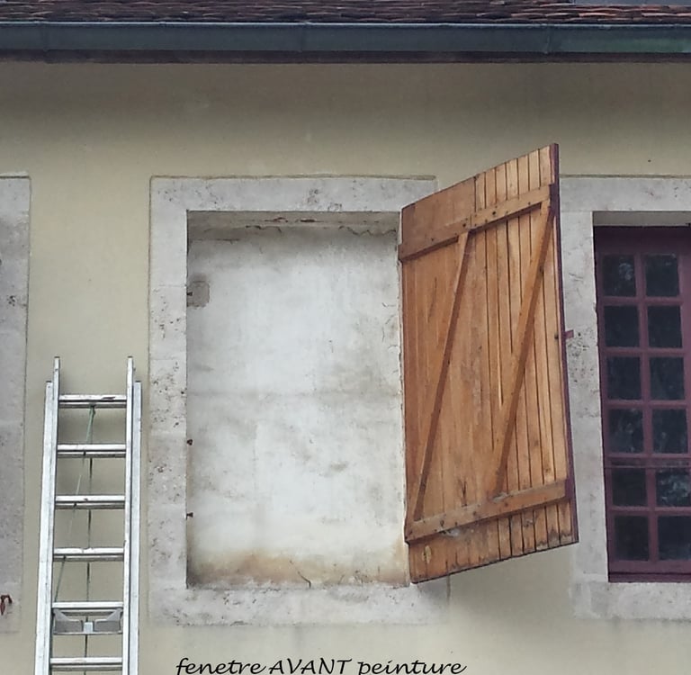 Fenêtre murée d'une façade avec un volet.
