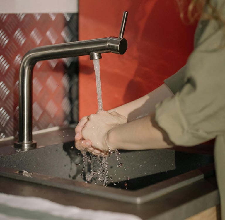 grifo de agua y manos de una persona que se lava