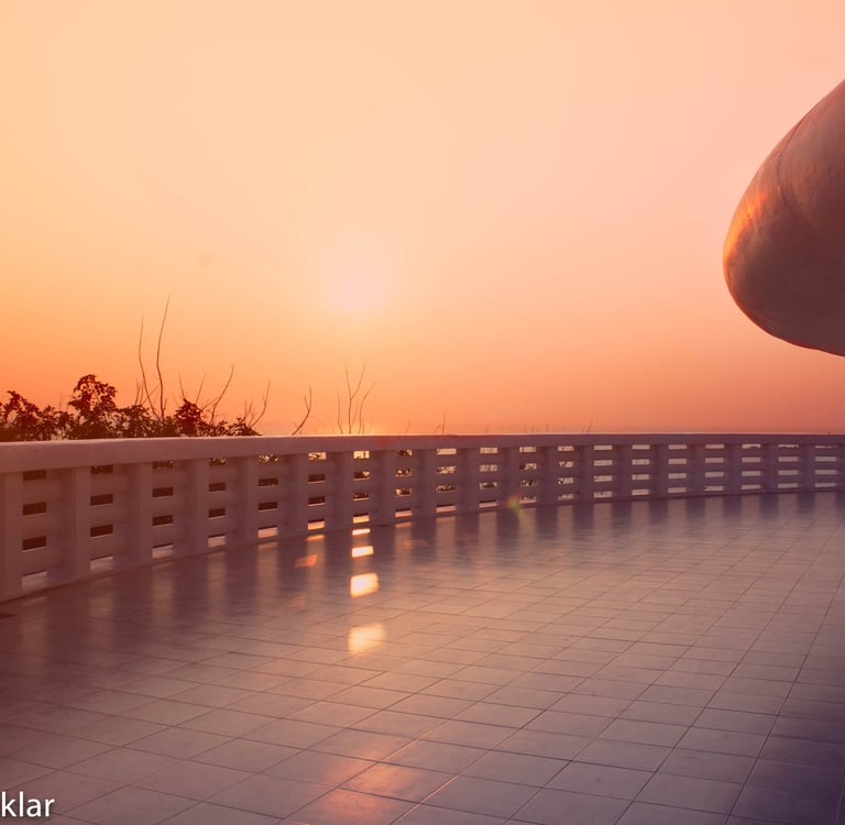 Golden sunset view from a modern white tiled balcony of a temple in Sri Lanka.