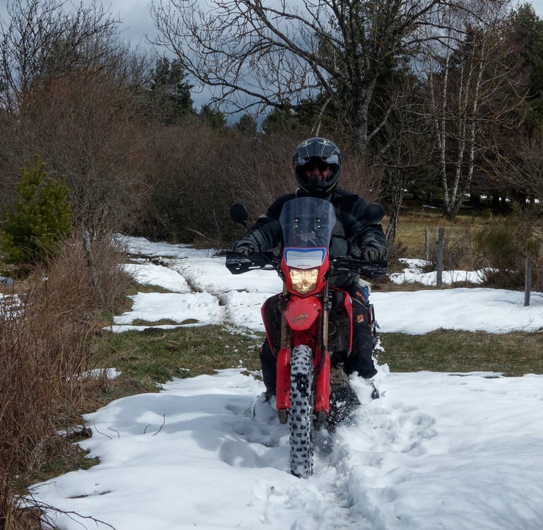 a man riding a motorcycle through the snow