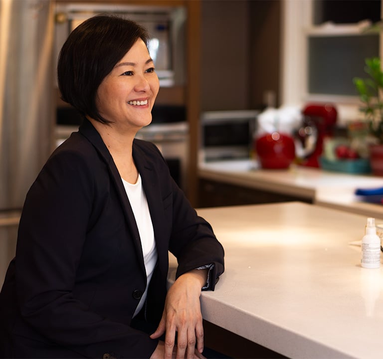 a woman sitting at a table looking to the right smiling