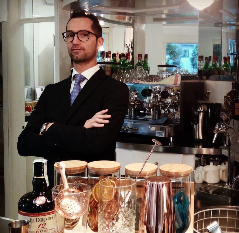 a man in a suit and tie standing in front of a bar