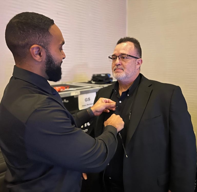 a man in a suit and glasses is getting mic'd up