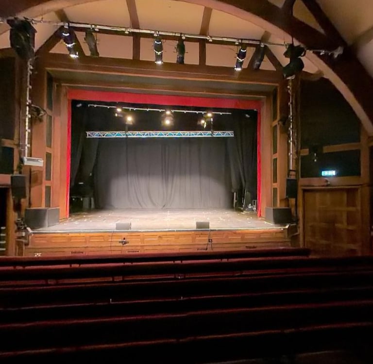 The Pleasance Theatre, a theatre with a large stage and cushioned benches.