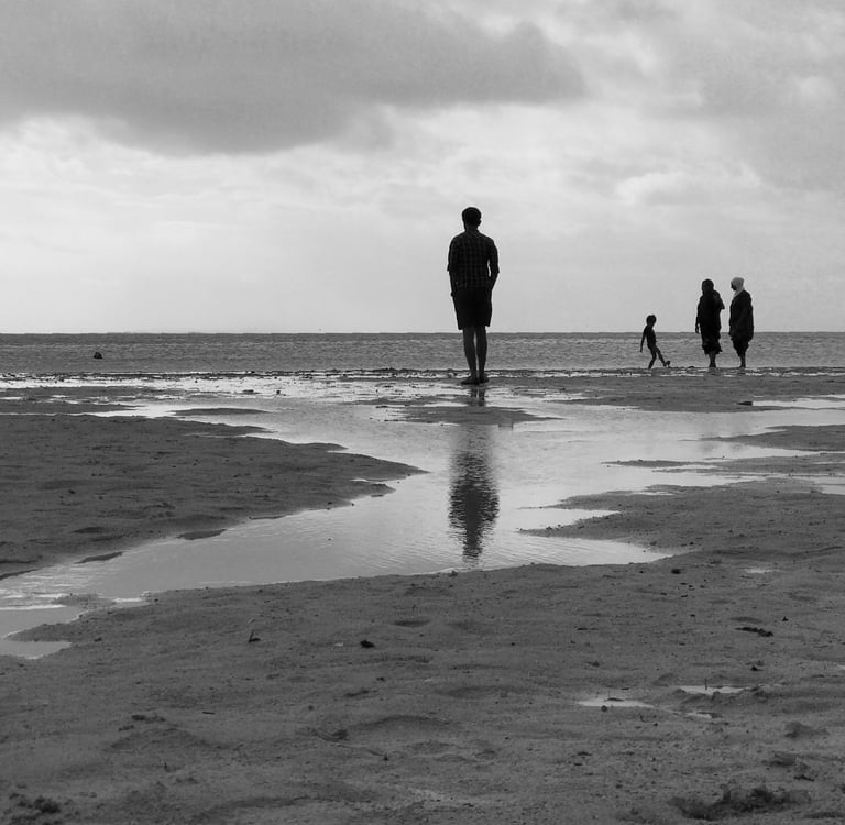 People walking along a Mauritian beach at low tide, Cape Town Photography Festival 2025.