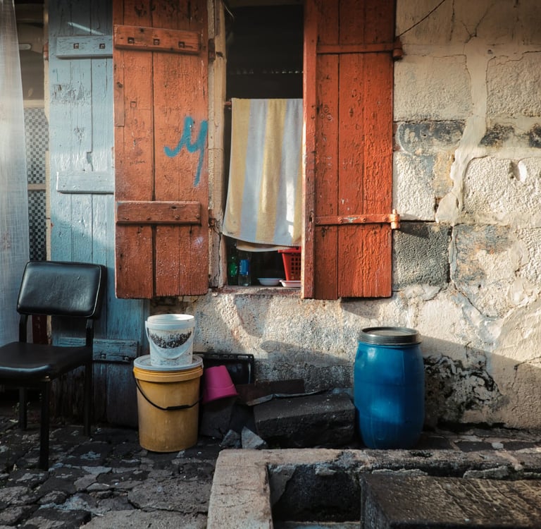 Street photography of a rustic house facade in Mauritius with colorful shutters.