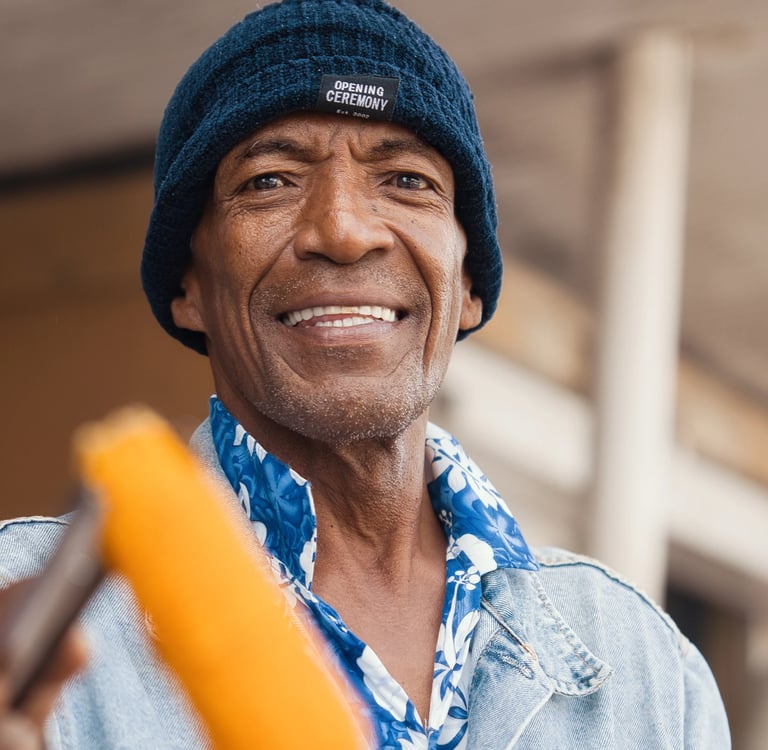 Man in a beanie hat smiling while holding roasted corn in Rodrigues.