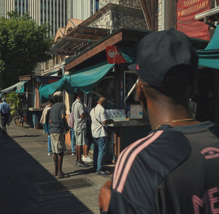 Street photography scene showing daily life outside food stalls at the Central Market in Port Louis, Mauritius