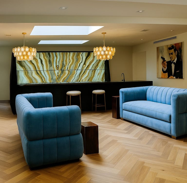 Blue tufted sofas in a stylish lounge with skylight, onyx bar, pendant lights, and James Bond art.