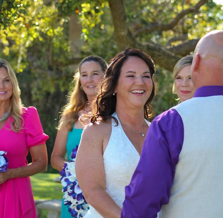 a bride and groomsmid are standing in front of a group of people