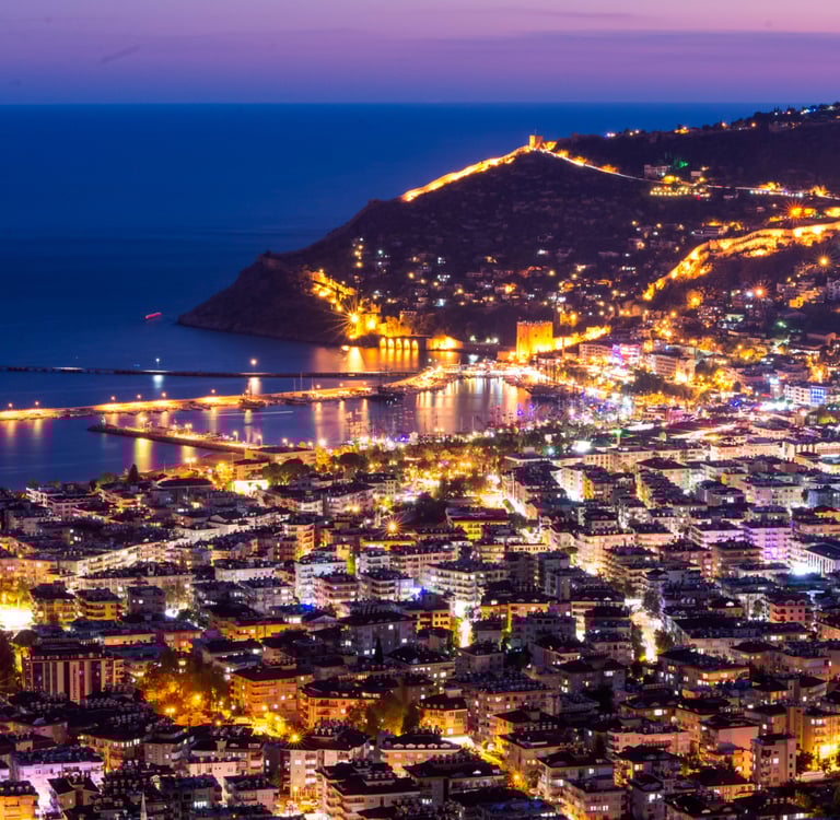 Stunning night view of Alanya city lights and the historical castle by the sea