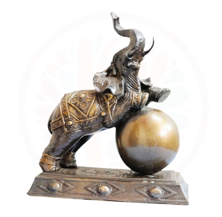 a statue of a man riding a elephant on a ball