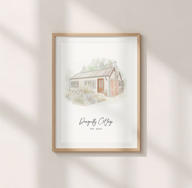 A minimalist ink and watercolor painting of a cottage hangs on a wall