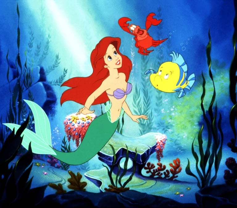 Ariel swims underwater with sea creatures in Disney’s The Little Mermaid (1989)