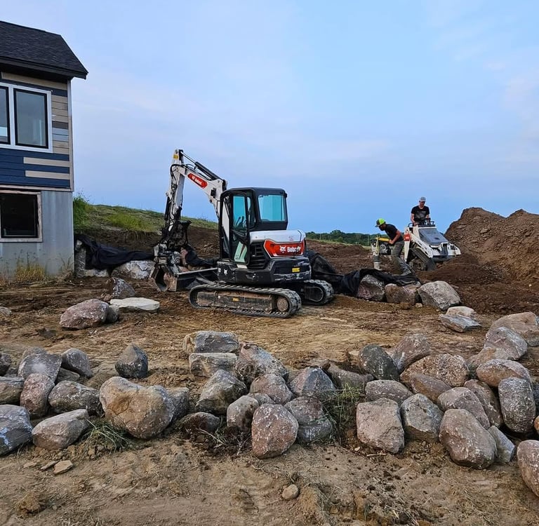 Bobcat Excavator and Bobcat mini excavator building a block retaining wall