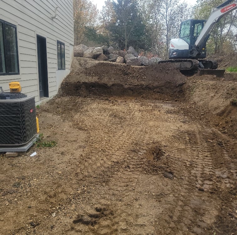 bobcat excavator digging dirt for boulder wall