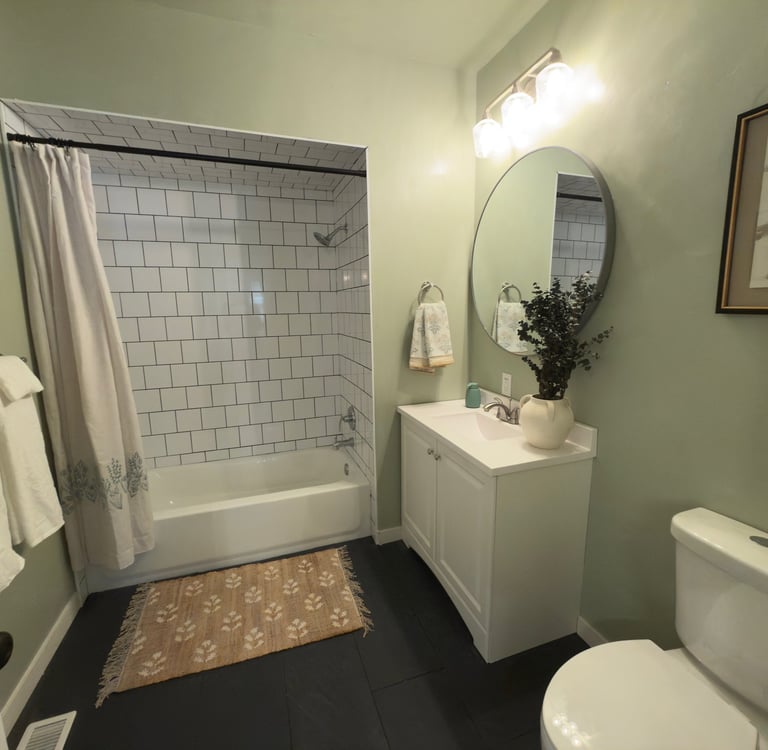 staged Modern bathroom in Ohio with sage green walls, subway tile bathtub.