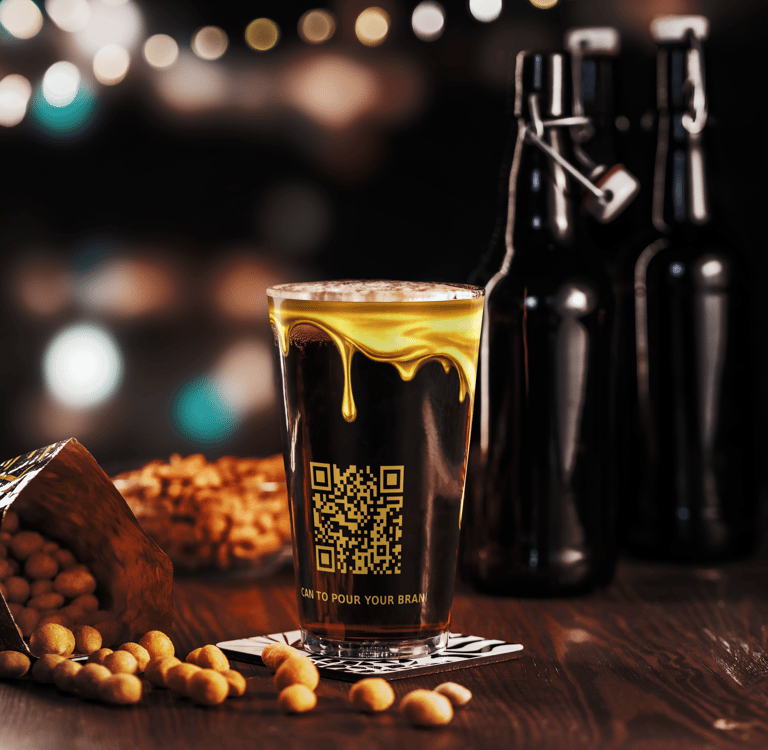 The Pour Shop pint glass with QR print on table in bar setting with bottles behind showing branded drinkware