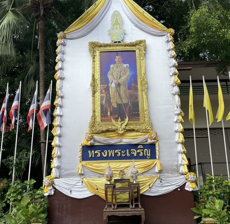 Goldgerahmtes Porträt des Königs von Thailand auf einem zeremoniellen Altar mit thailändischen Flagg