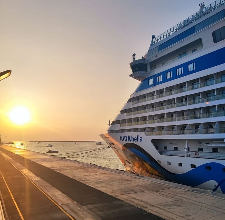 Das Kreuzfahrtschiff AIDAbella liegt während eines goldenen Sonnenuntergangs über dem Ozean