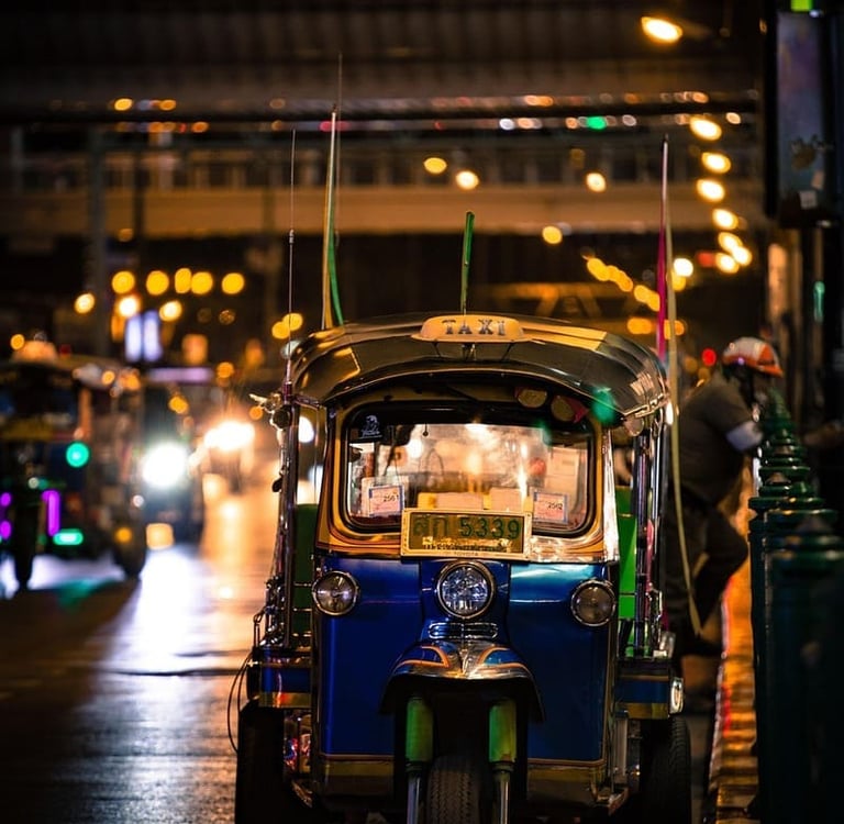 Ein farbenfrohes blau-grünes Tuk-Tuk-Taxi parkt
