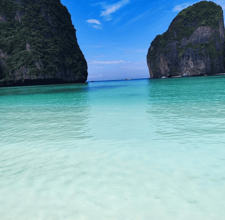 Kristallklares türkisfarbenes Wasser in der Maya Bay, Thailand, mit tropischen Kalksteinfelsen