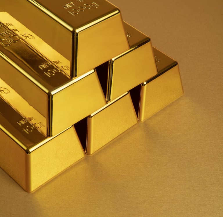 Ein Stapel glänzender 24-Karat-Goldbarren mit einem Gewicht von jeweils 1000 g auf einer spiegelnden