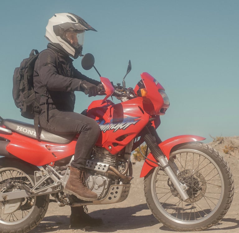 man sitting on his motorcycle in the desert