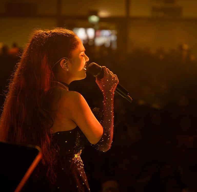 a woman in a black dress singing into a microphone