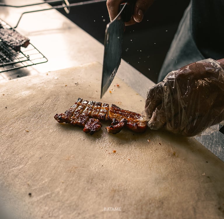 chef chopping grilled pork at BPK Chika Batam