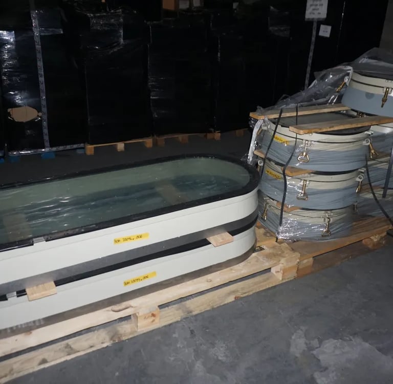 Onze scheepsramen en patrijspoorten op pallets, verzendklaar in ons magazijn