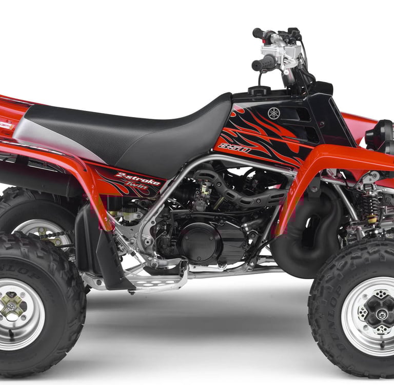 Red Yamaha Banshee 350 twin 2-stroke sport ATV with flame decals on a white background.