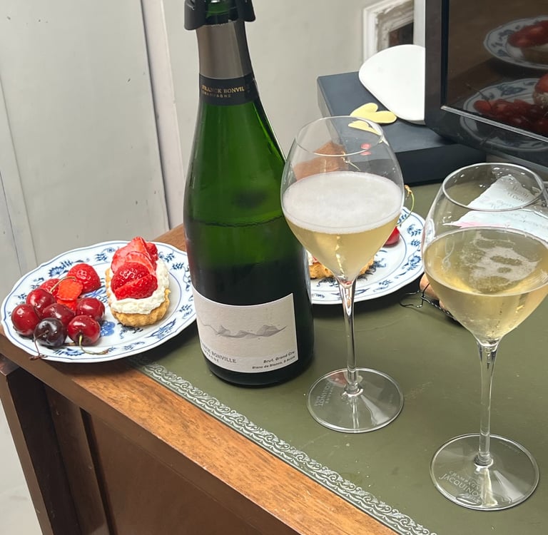 Champagne, fresh berries and strawberry pastries arranged on a table, capturing a simple moment of everyday luxury.