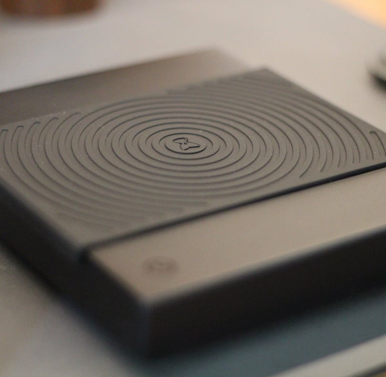 A black TIMEMORE coffee scale with a grooved rubber heat resistant mat for espresso brewing.