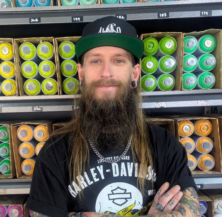 HAVRE Graffiti spray paint artist, Paul Woronecki in front of spray cans.