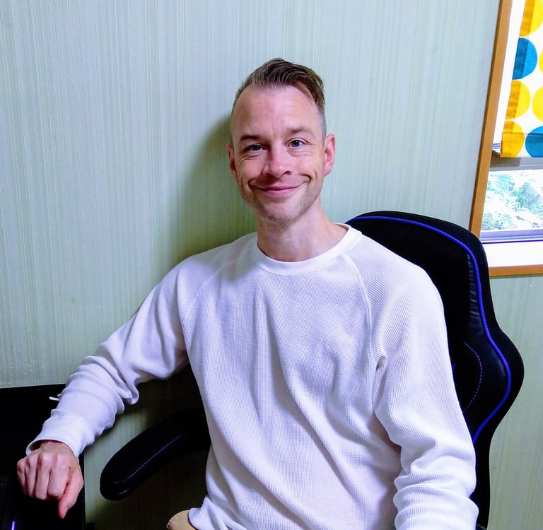 an online English teacher sitting at a computer desk