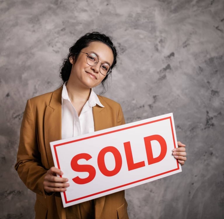 Realtor holding a sold sign in front of a home in a Chattanooga Tennessee neighborhood with Lookout Mountain